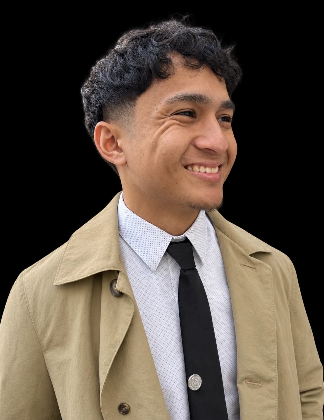 Austin Bartolome, smiling, wearing a tan coat over a white shirt and black tie.